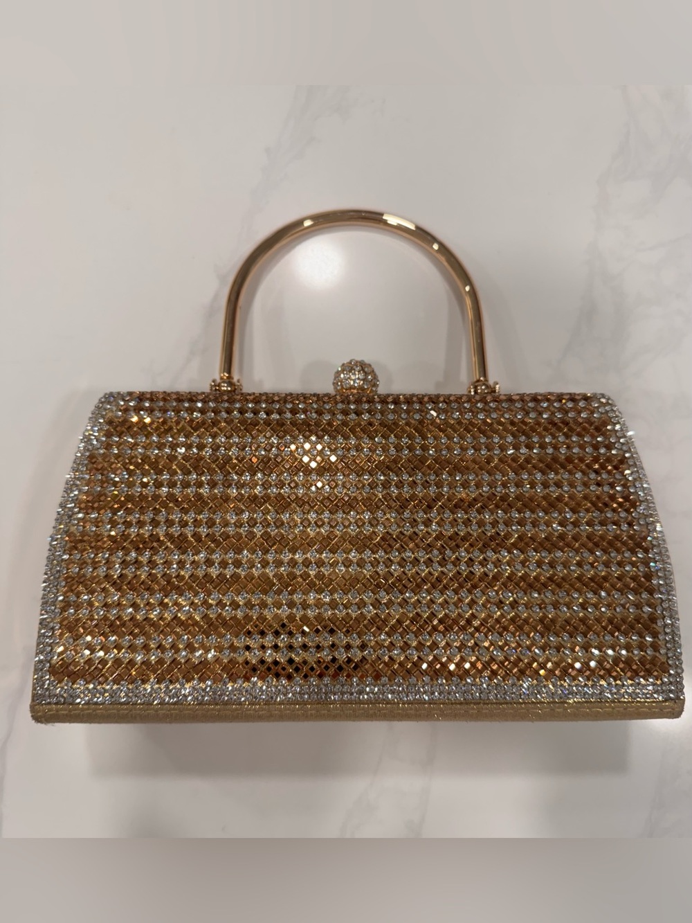 Gold metallic clutch with rhinestone embellishments and a gold handle